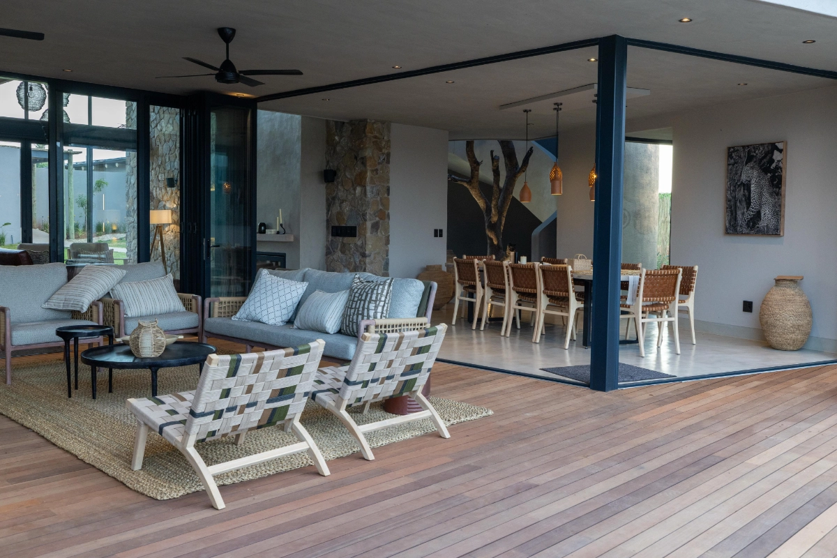 Spacious open-plan living and dining area at Izakithi River Villa, opening onto the deck with panoramic bush views.